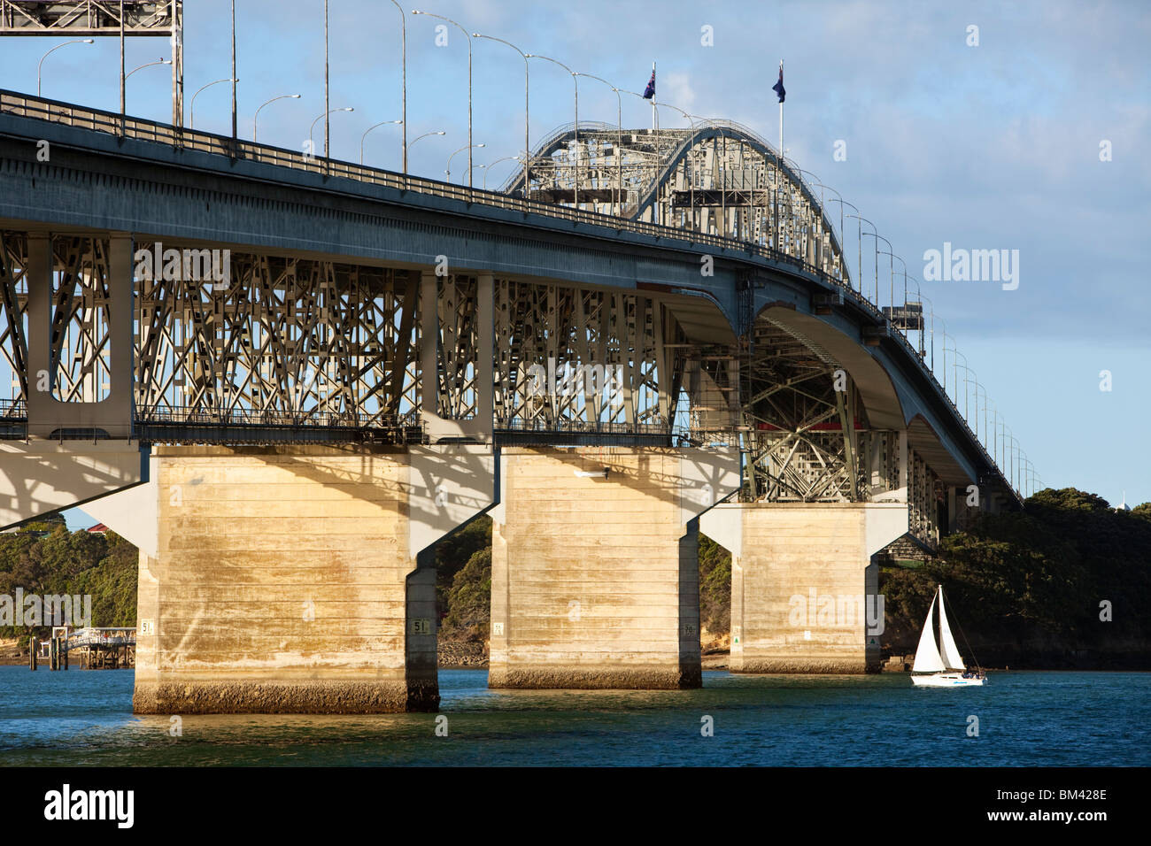 A yacht passes under the Auckland Harbour Bridge. Auckland, North Island, New Zealand Stock Photo