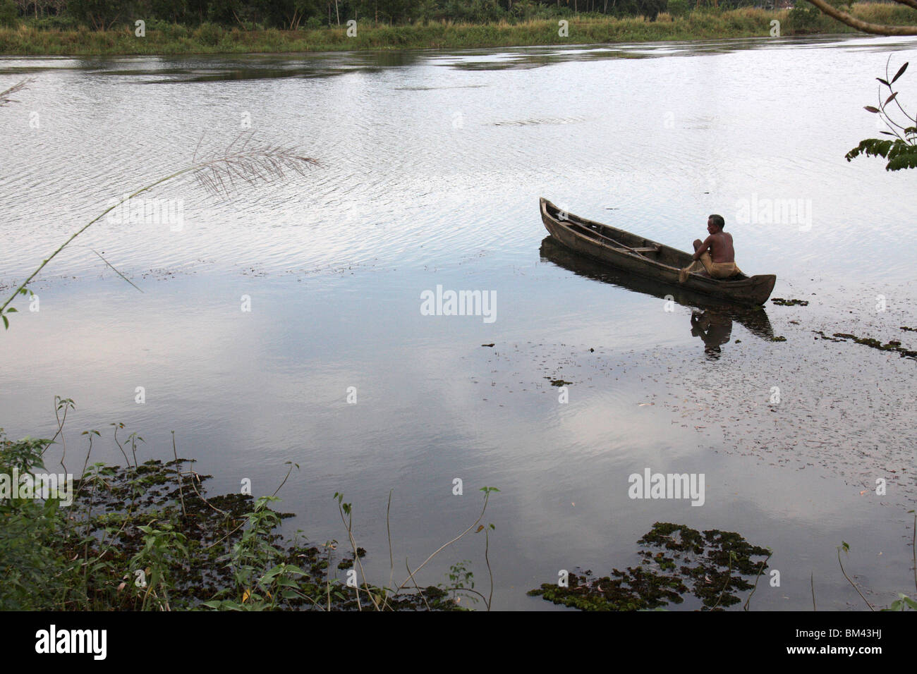 local village fisherman fishing in a wooden boat in the back waters of kerala,india,asia Stock Photo