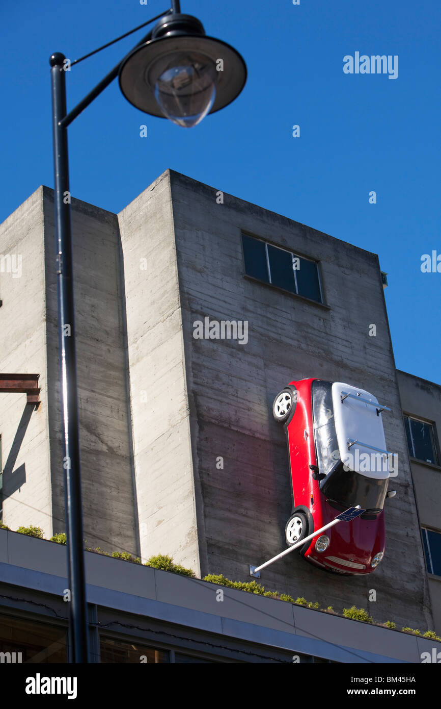 Quirky artwork - a car is suspended above Sol Square on Struthers Lane. Christchurch, Canterbury, South Island, New Zealand Stock Photo