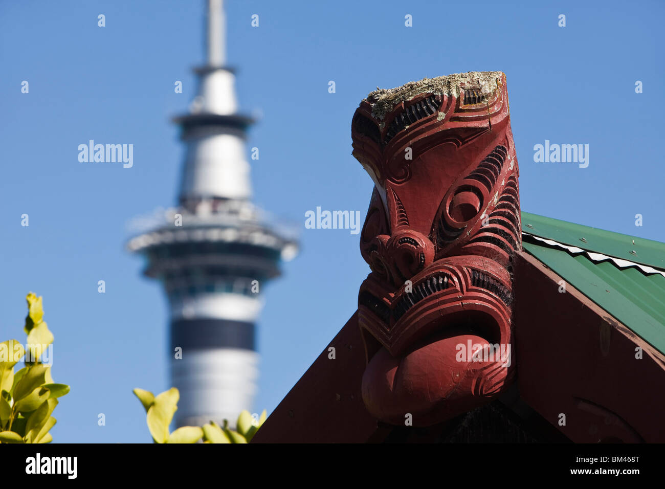 Maori carving with the Sky Tower in the background. Auckland, North Island, New Zealand Stock Photo