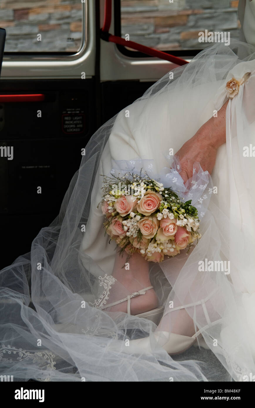 Bride with flowers bouquet inside a car Stock Photo