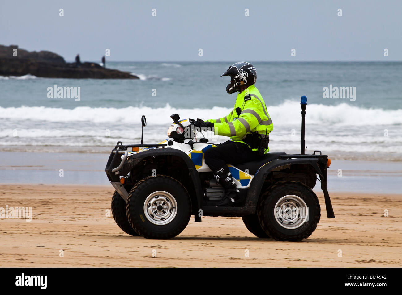 Police officer on quad patrolling beach at Portrush Stock Photo