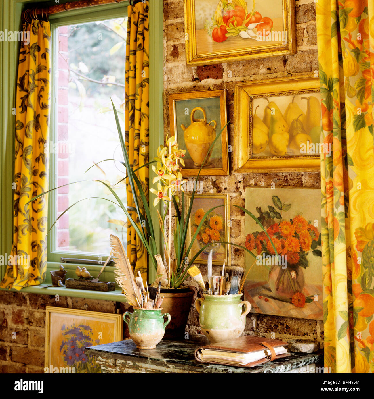 Detail of artwork and table display with daffodils and paintbrushes in confit jars. Stock Photo