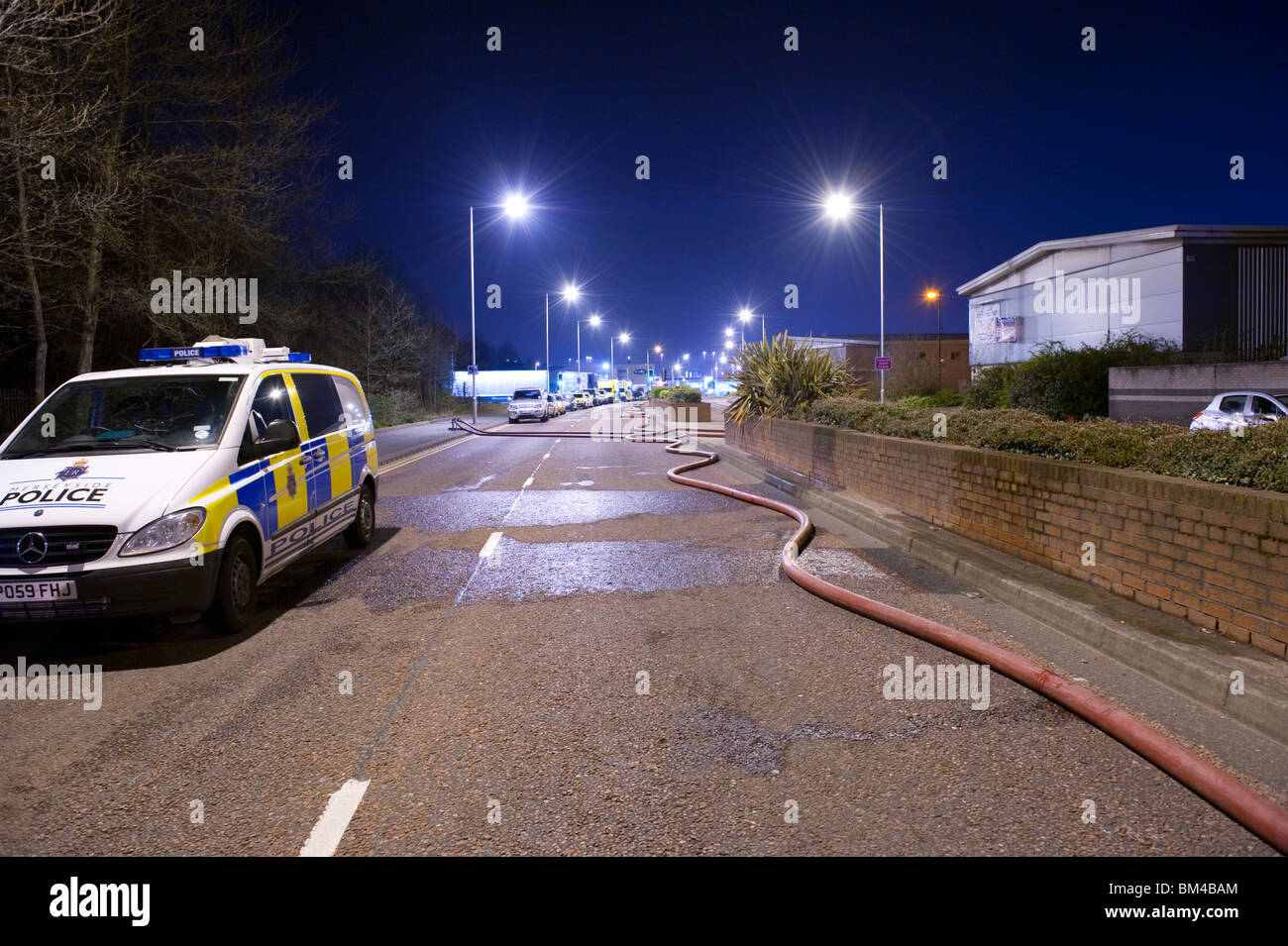 Fire hose and police car in road at night Stock Photo