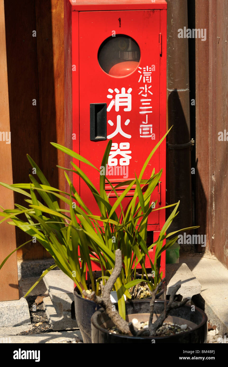 A Japanese fire extinguisher bottle in front of a residential building
