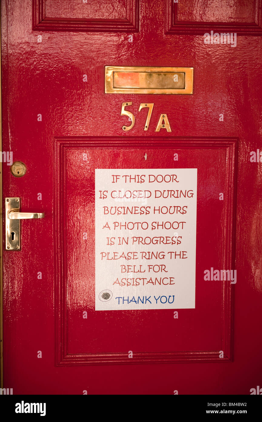 Photographer studio shoot in progress sign on red door Stock Photo