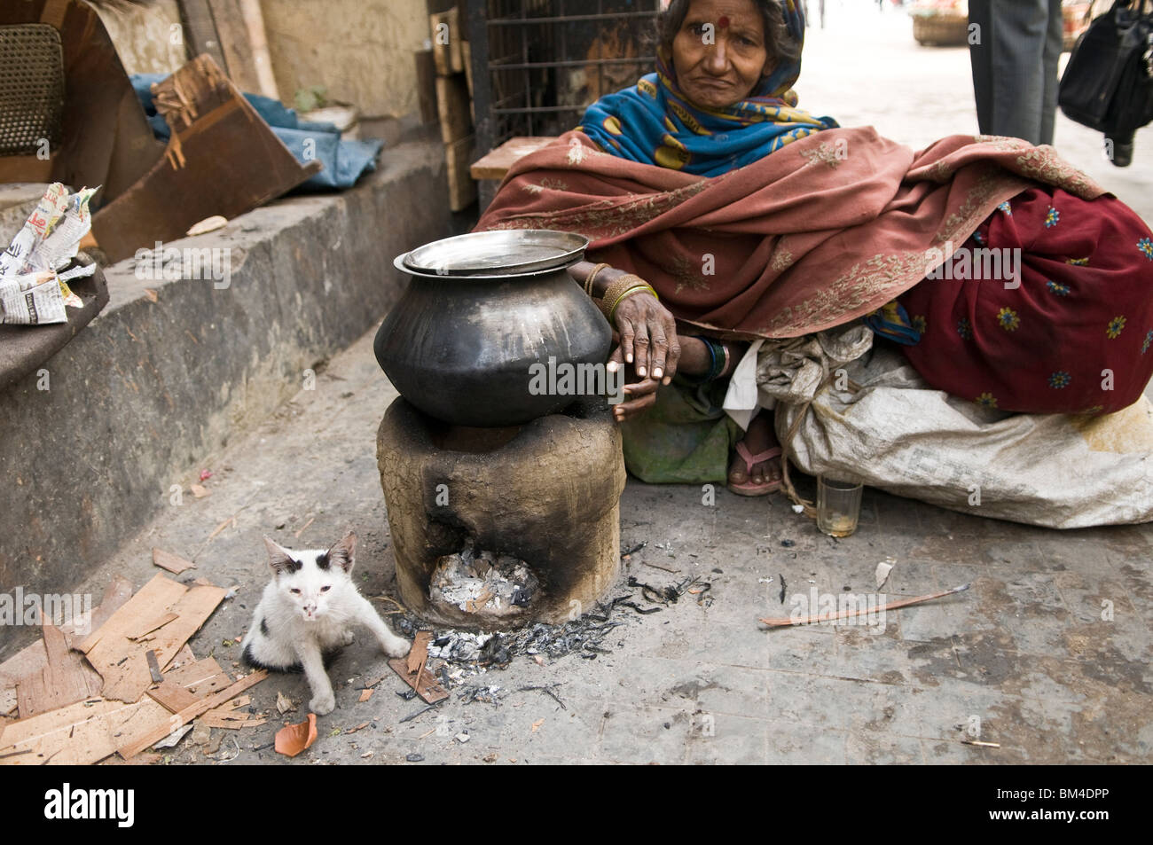 An Indian beggar with her kitty cat in the streets of Kolkata. Stock Photo