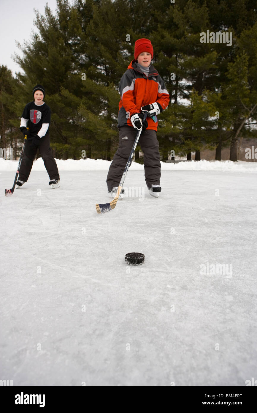 Boys playing hockey on a frozen pond in Quechee, Vermont Stock Photo