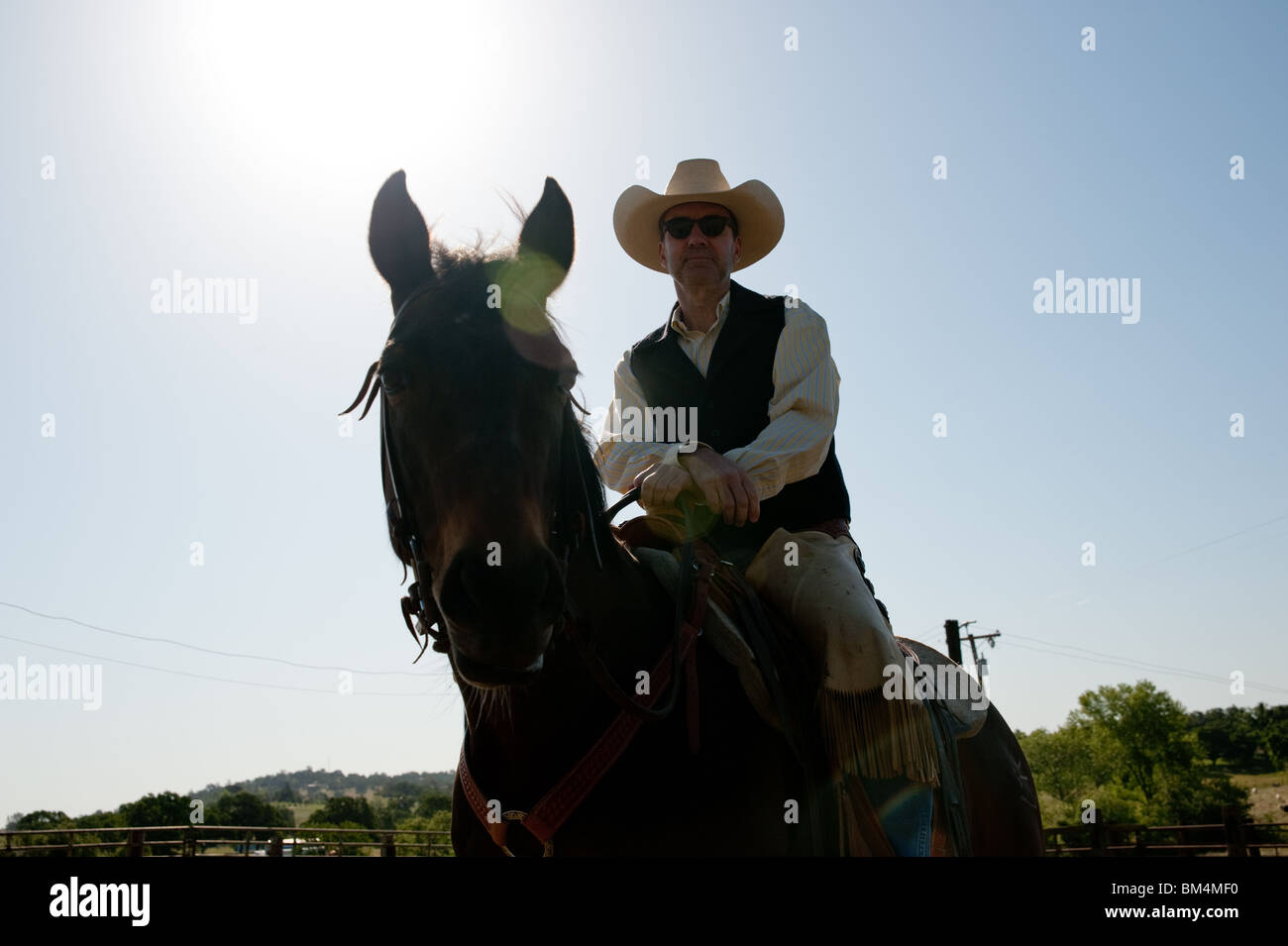 Cowboy riding his horse with the sky in the background Stock Photo