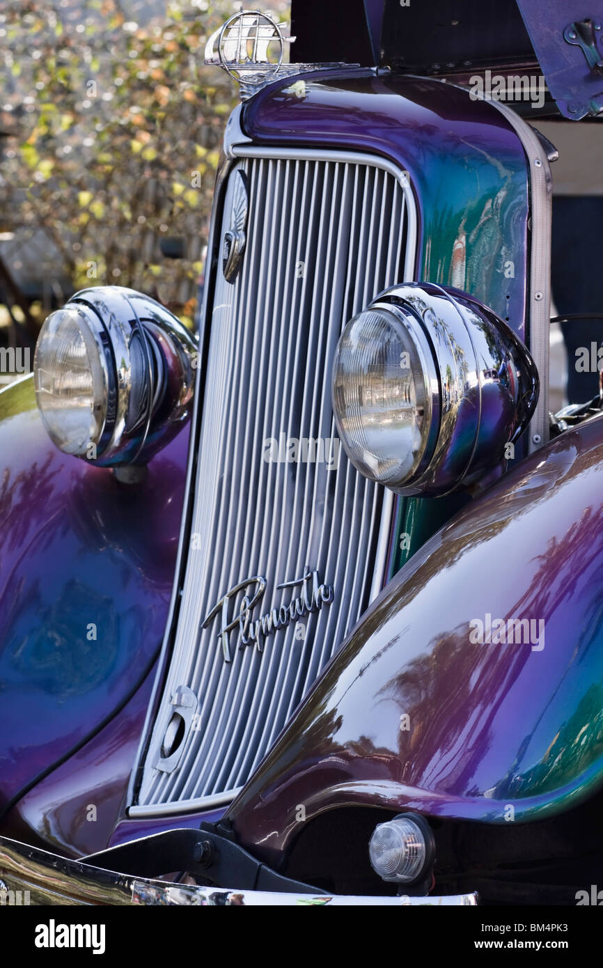 Radiator grill and headlamps on a colourful, restored classic Chrysler Plymouth. Stock Photo