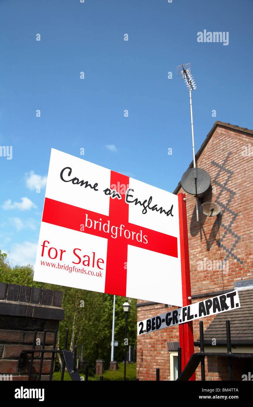 Estate agent for sale sign joining in the football madness Stock Photo