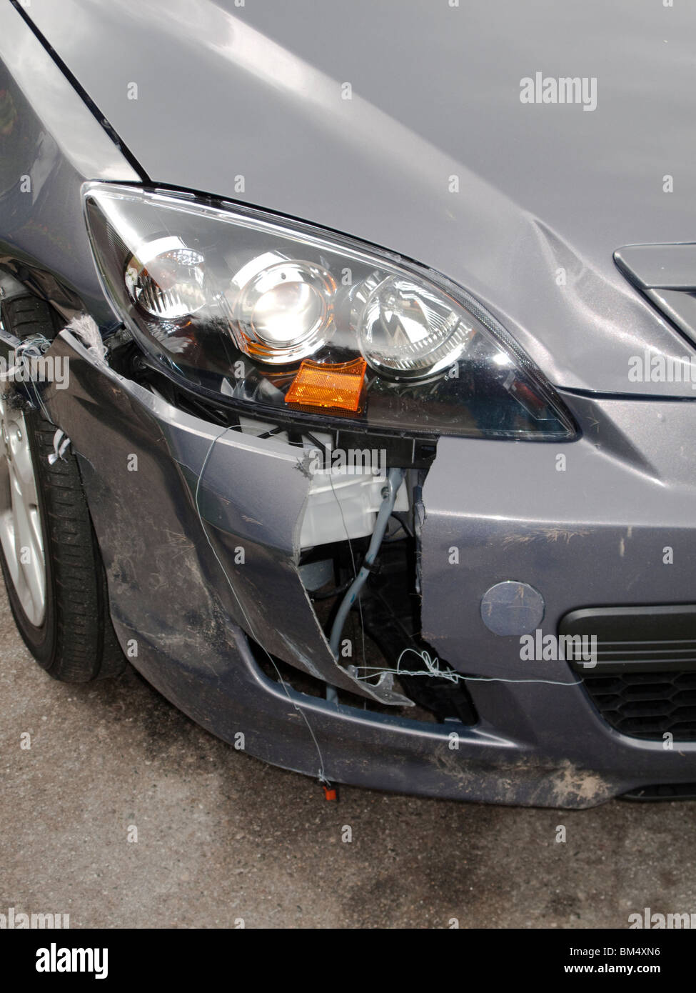 Broken in a crash, a car's brittle plastic bumper cover shows the vehicle's vulnerability to collision damage. Stock Photo