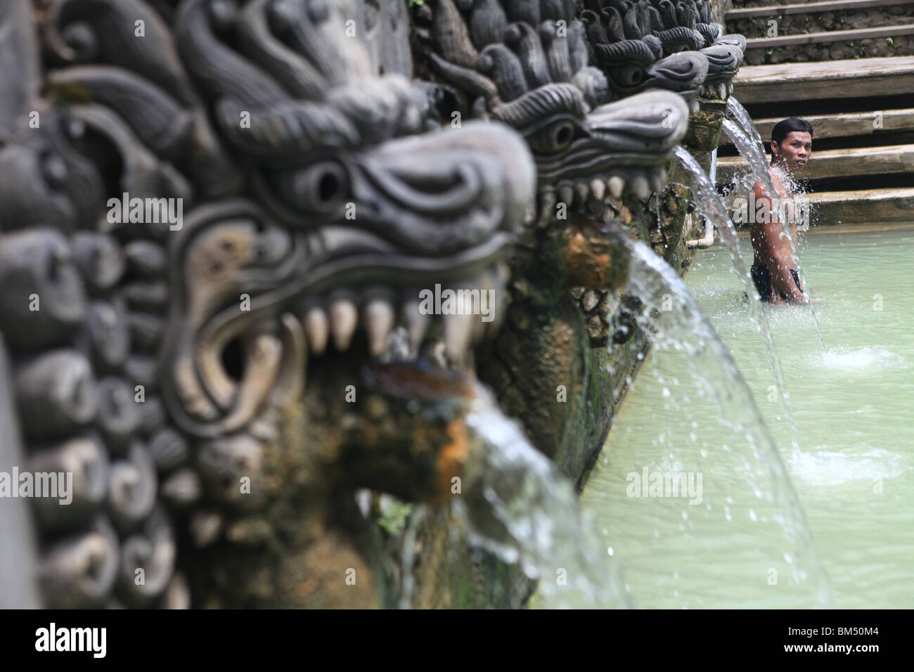 A man at the thermal spring water swimming pool in Bali, Obyek Wisata, Air Panas Banjar, near Lovina in Bali, Indonesia. Stock Photo