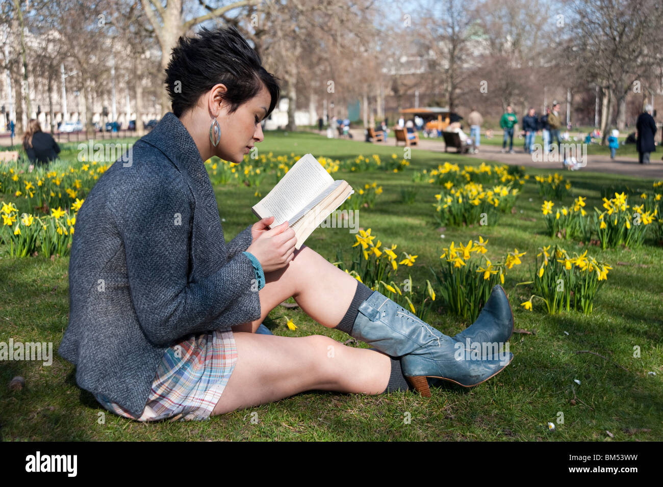 Young woman reading a book in St James's Park, London, England, UK Stock Photo