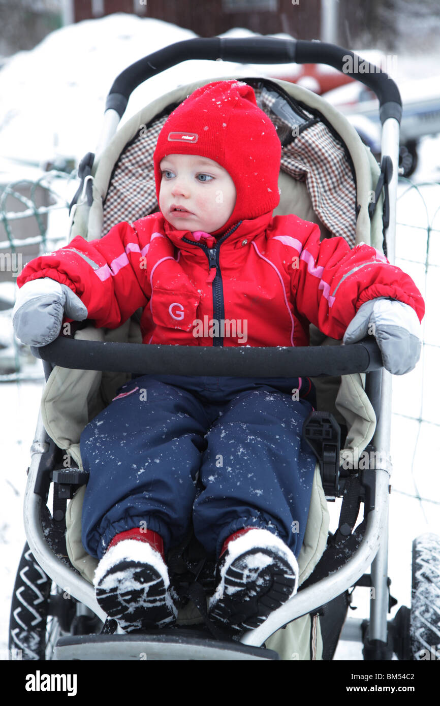 BABY IN FINLAND WINTER 18 months old girl baby toddler kid sat sitting in a buggy pram in the winter snow model released Stock Photo Alamy