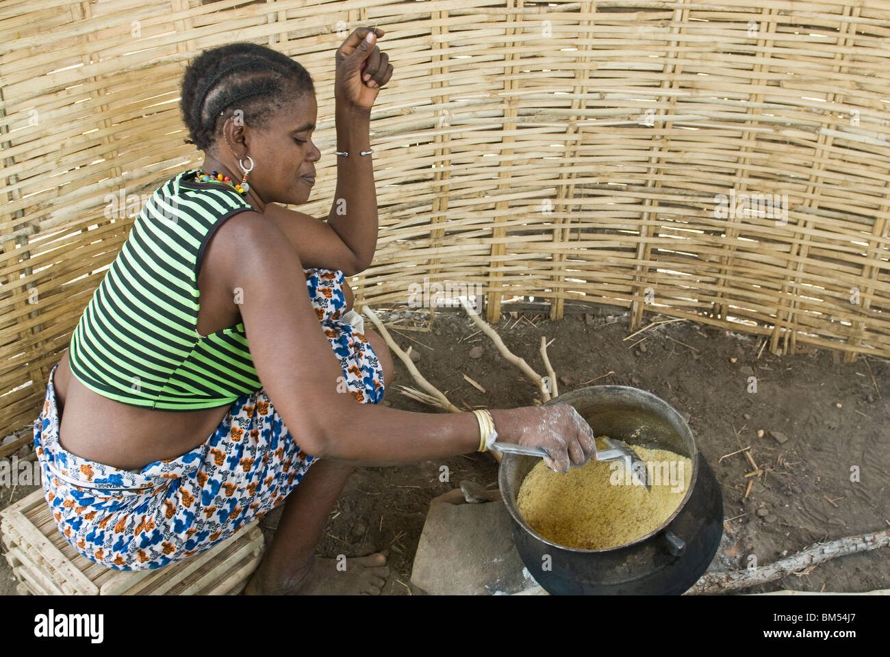 African bedik women cooking crushed peanuts on the fire, Iwol village, Bassari country, Senegal, Africa. Stock Photo