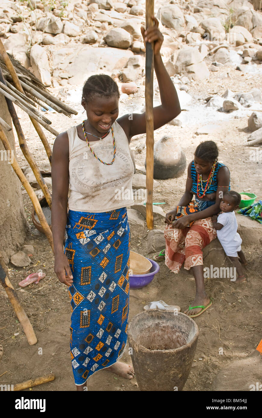 African bedik woman pounding peanuts, Iwol village, Bassari country, Senegal, Africa. Stock Photo
