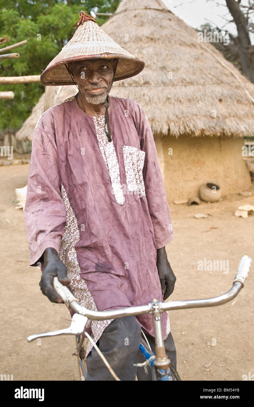 Old Bassari man with funny hat and bicycle looking to the camera, Village  of Ibel, Bassari country, Senegal, Africa Stock Photo - Alamy