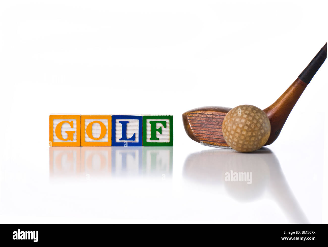 Colorful children's blocks spelling GOLF with antique golf ball and wooden driver Stock Photo