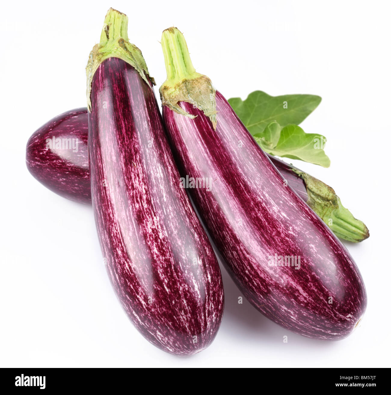 Purple eggplants with leaves on white background Stock Photo