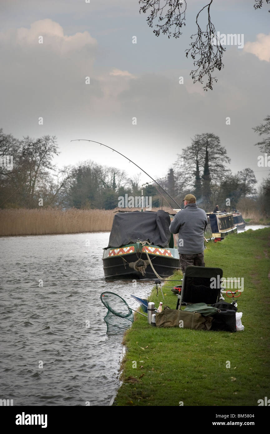 man fishing on trent and mersey canal in dull weather Stock Photo