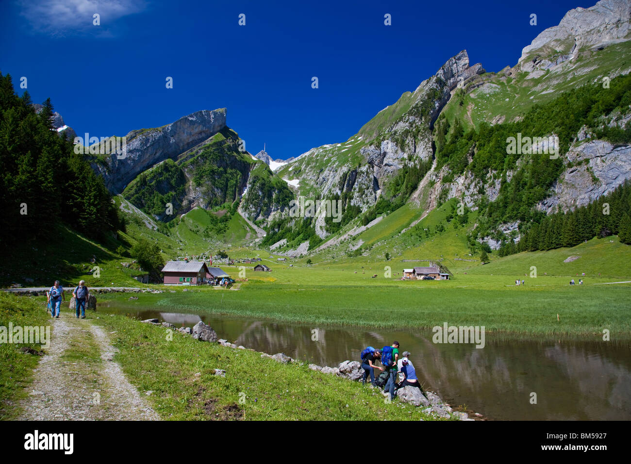 Hikers near Seealpsee Lake in the Alpstein mountains, Mt Saentis in the back, Canton Appenzell Innerrhoden, Switzerland, Europe Stock Photo