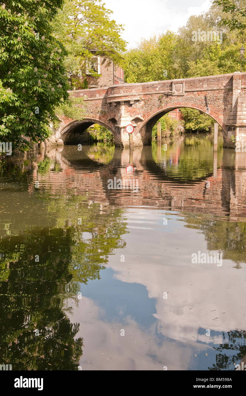 Buttressed bridge over river with clouds in the reflection in the river Stock Photo