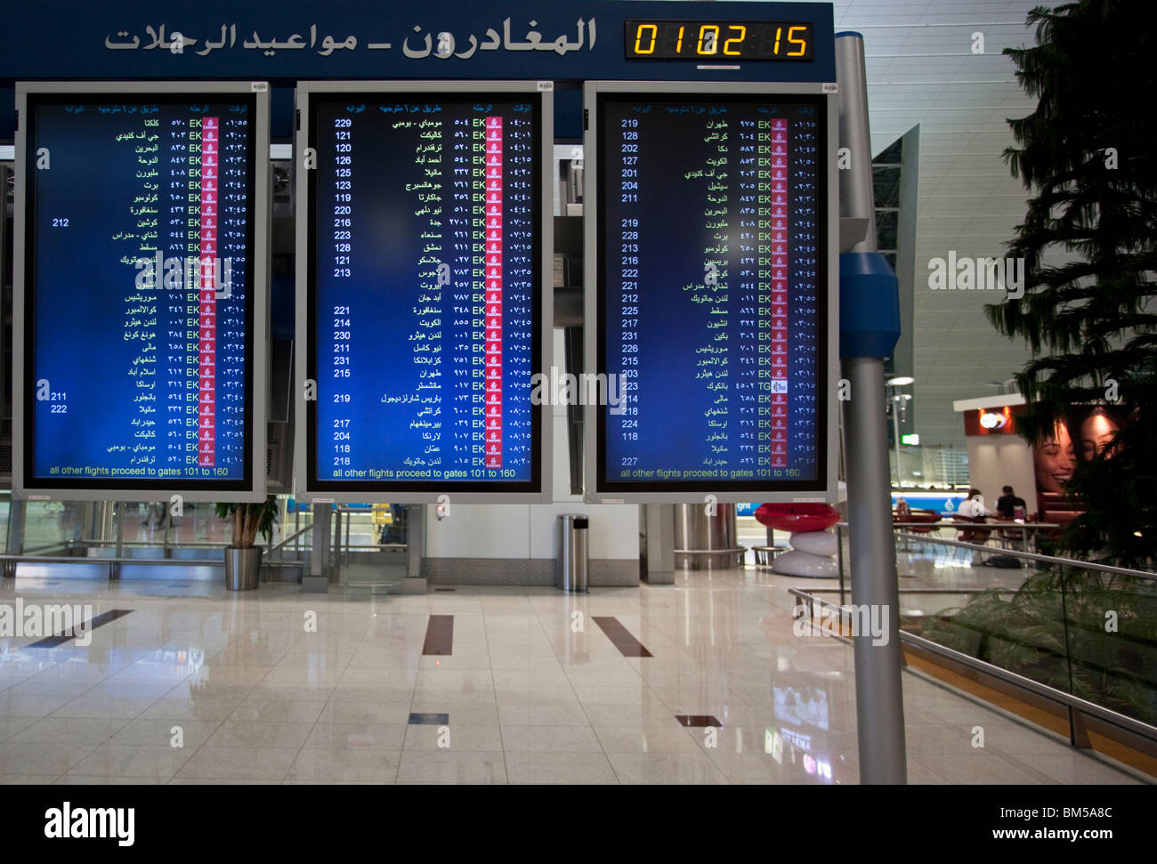 Departure board indicating destinations in Arabic language and script, Dubai International airport DXB Stock Photo