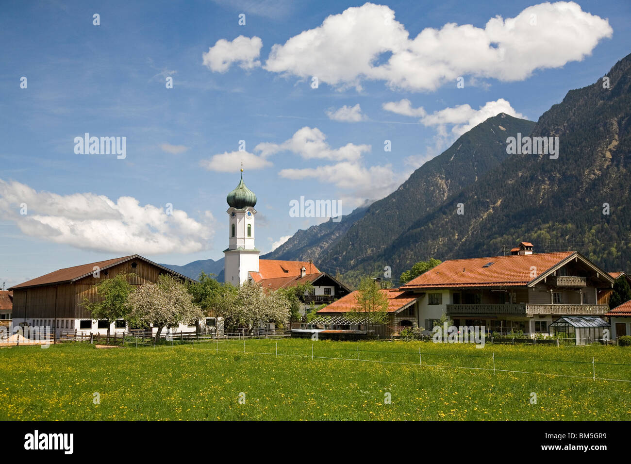 An onion domed church stands at the foothills of the Alps at Farchant ...