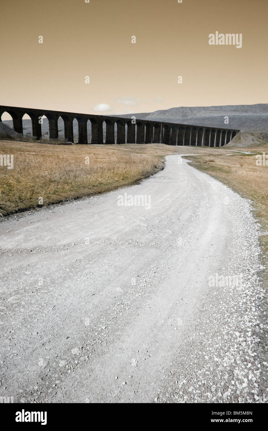 A long track to a dark ominous railway viaduct. Stock Photo