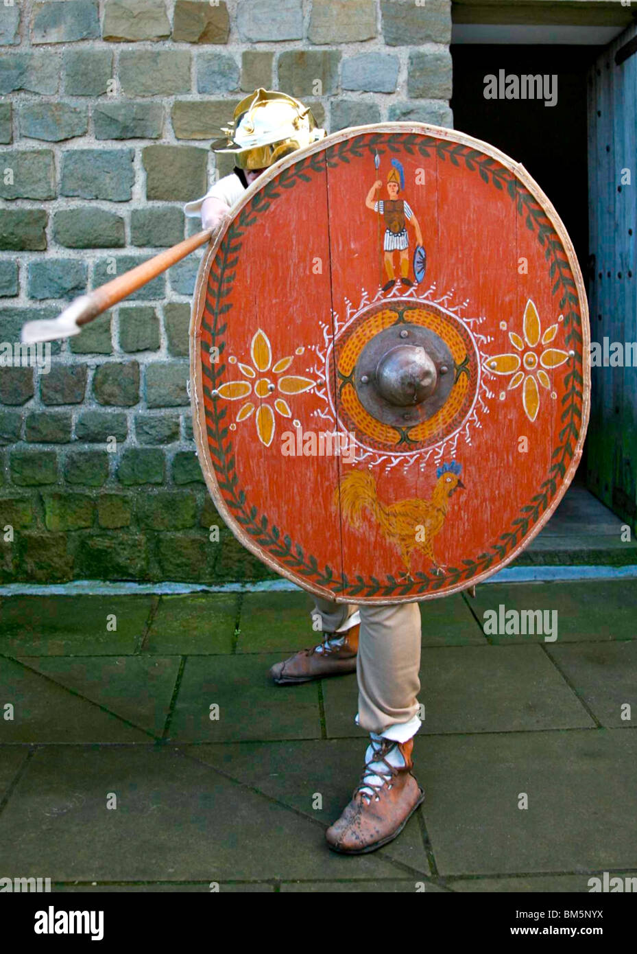 Roman costume dressed soldier in defense position with shield and spear colour Stock Photo