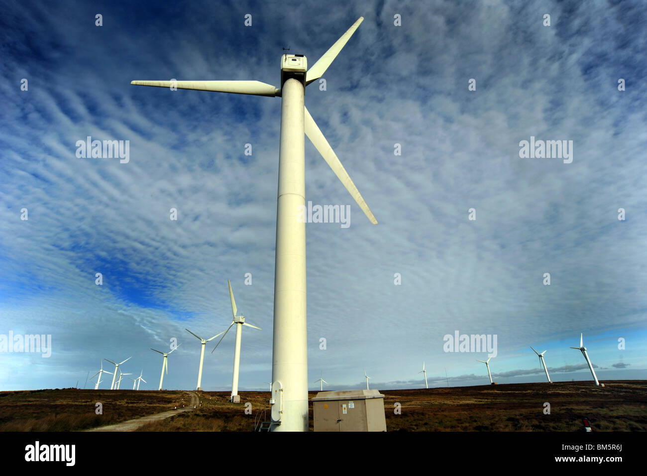 Windfarm turbine against a dramatic blue sky Stock Photo