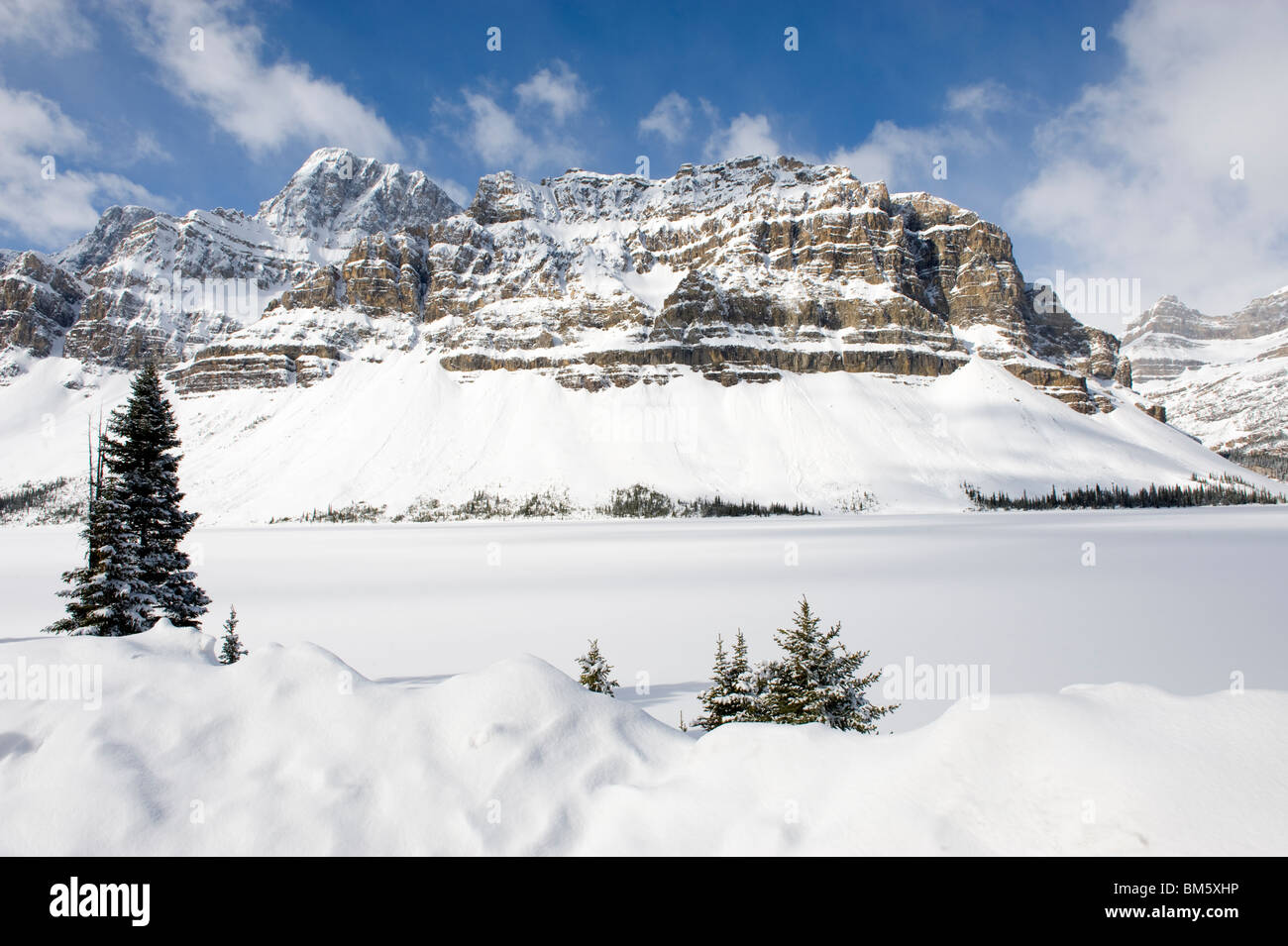 A view of a frozen and snowed over Bow Lake near Banff in the Canadian Rockies Stock Photo