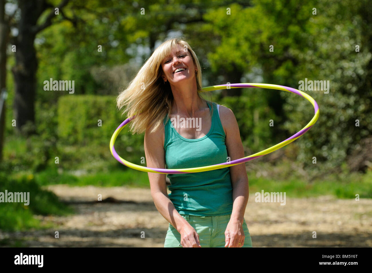 Woman using a hula hoop to exercise her neck muscles Stock Photo