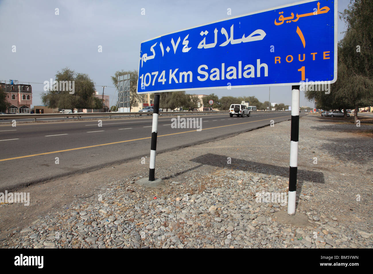bilingual street direction sign, highway route No1 near Muscat showing 1074 km distance to Salalah,Oman.Photo by Willy Matheisl Stock Photo