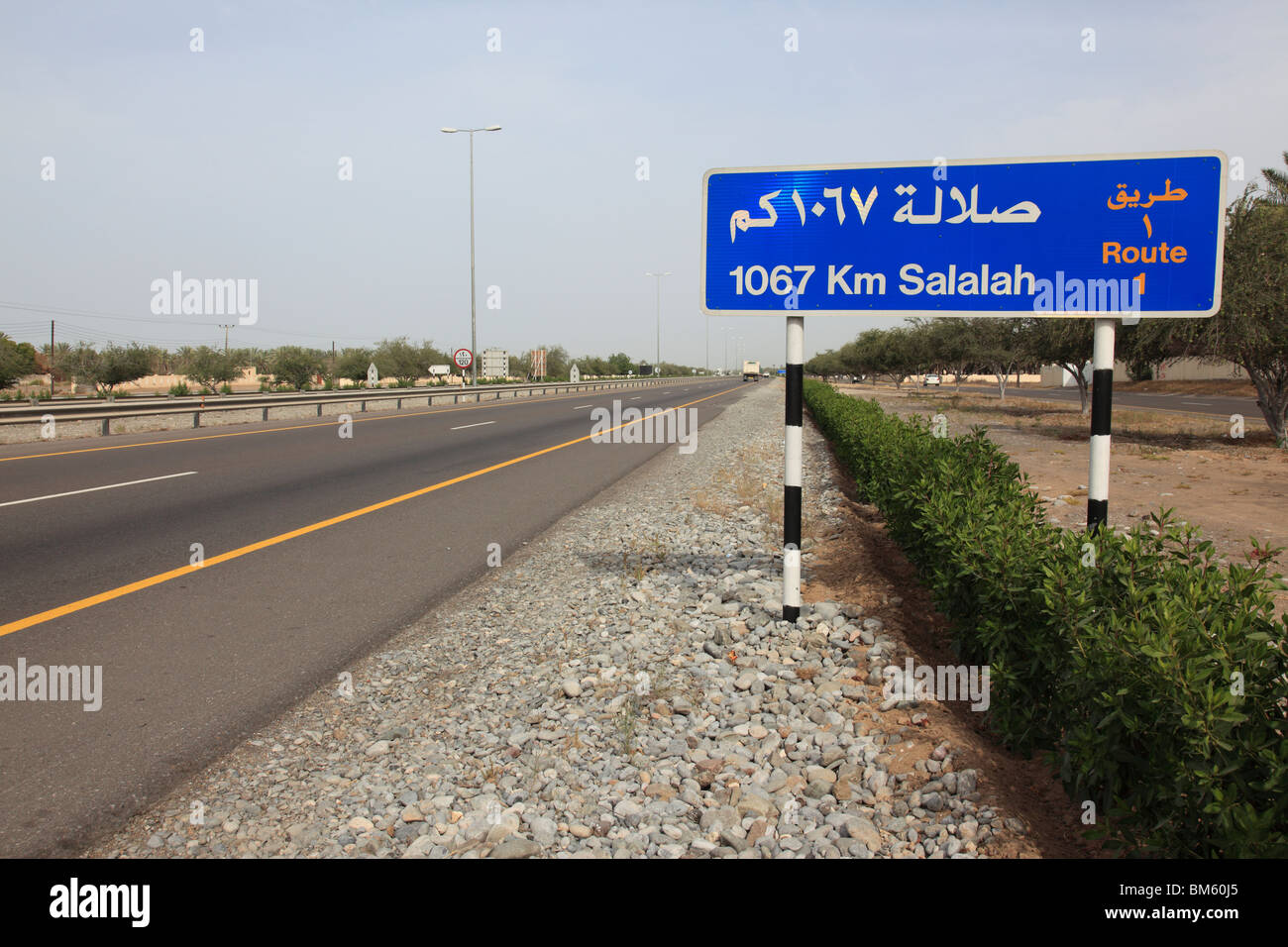 bilingual street direction sign, highway route No1 near Muscat showing 1067 km distance to Salalah, Oman.Photo by Willy Matheisl Stock Photo