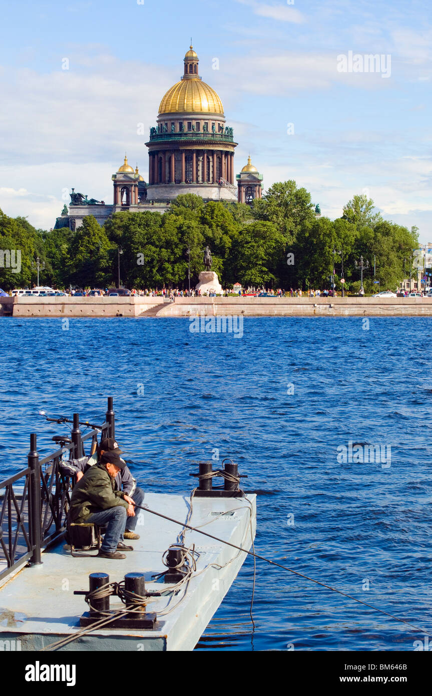 Angler on River Neva, St Petersburg, Russia. Across the river is the dome of St Isaac's Cathedral Stock Photo