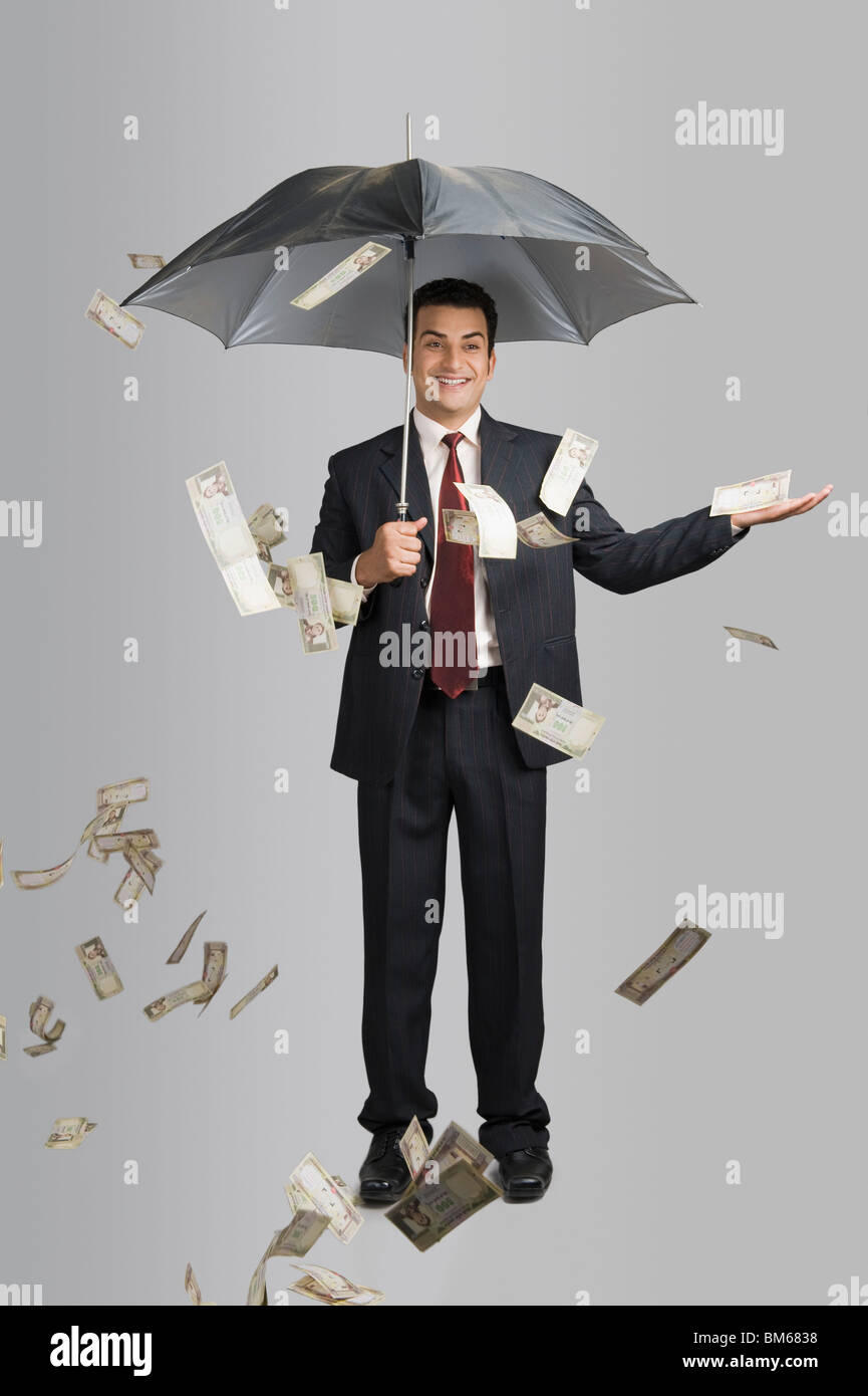 Money raining over a businessman Stock Photo