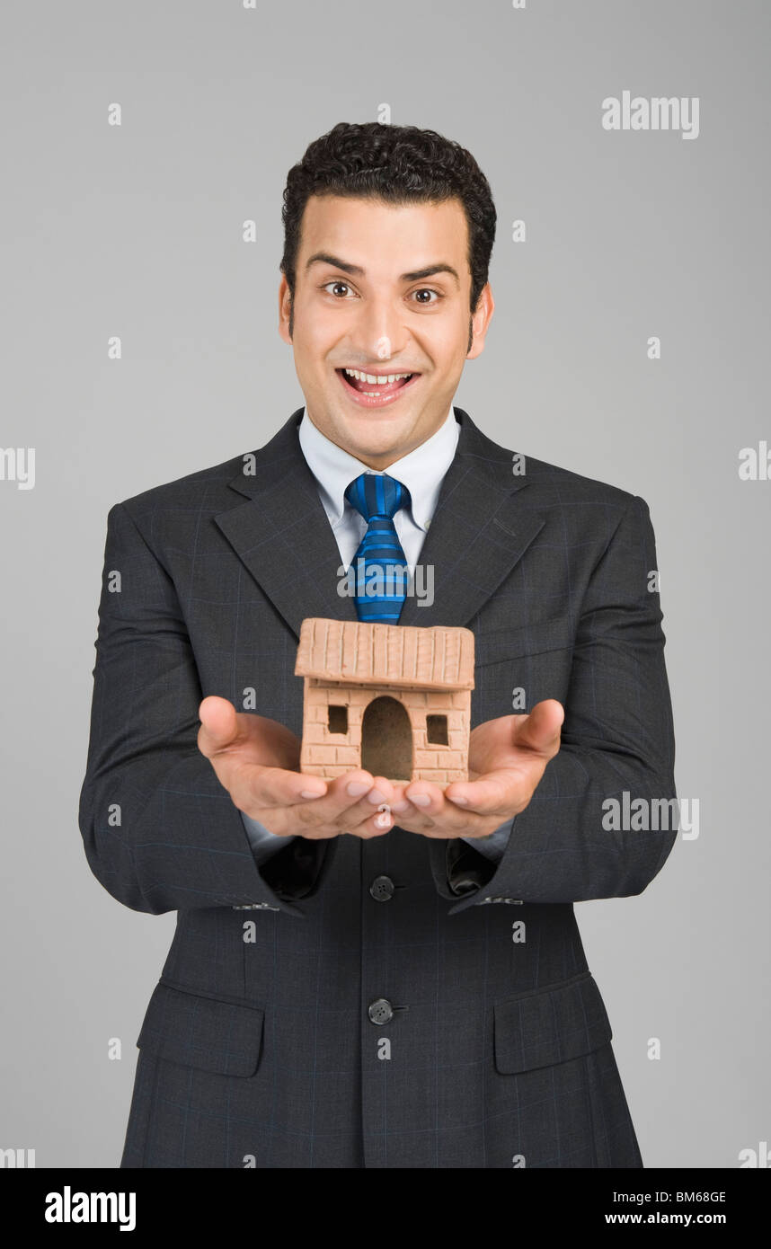 Businessman holding a model home Stock Photo - Alamy