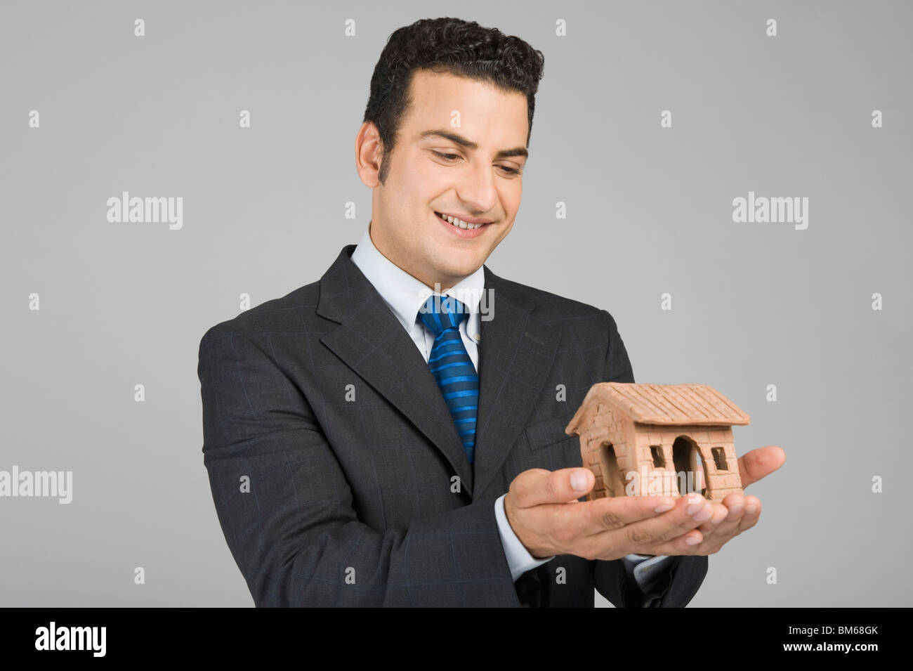 Businessman holding a model home Stock Photo - Alamy