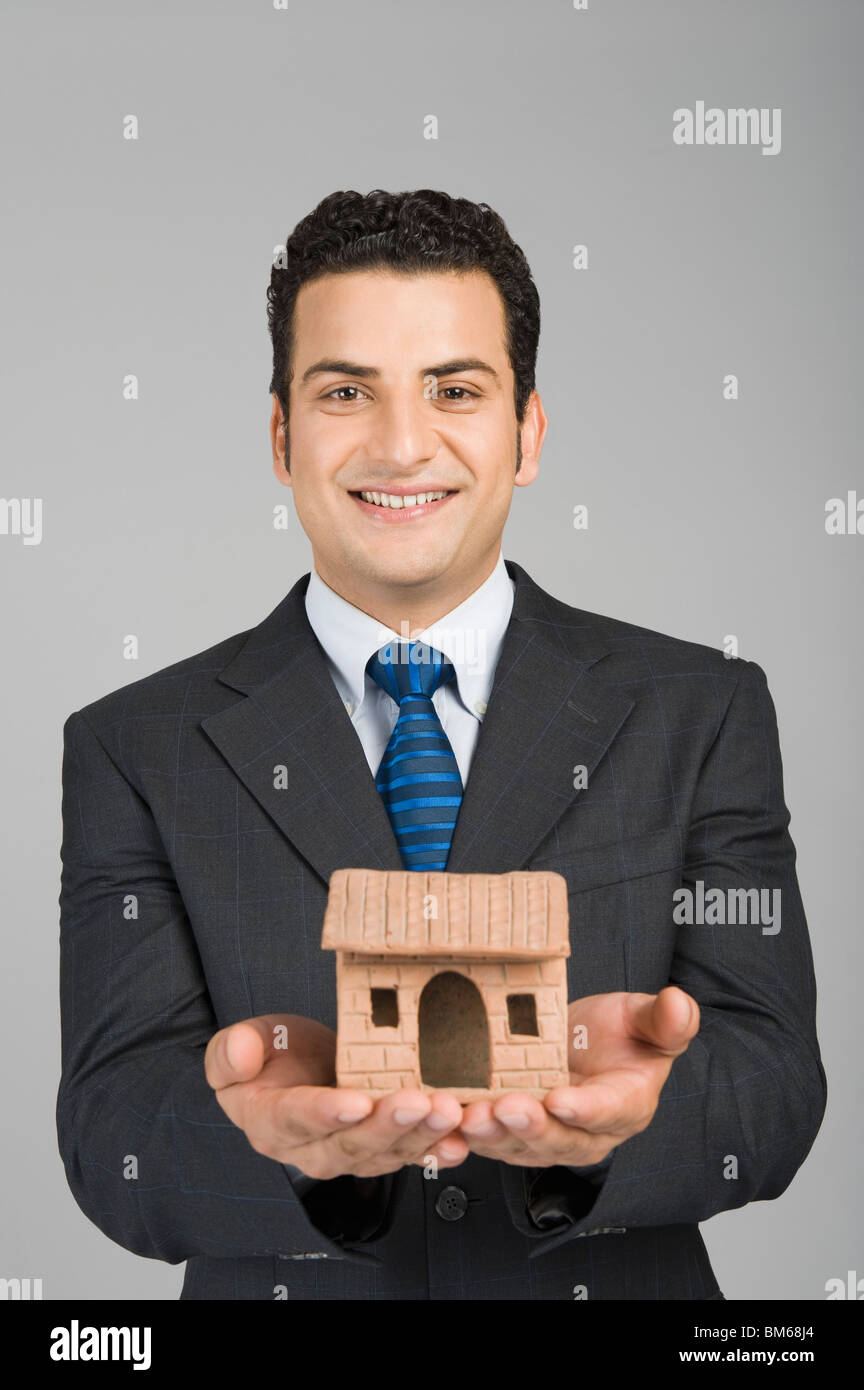 Businessman holding a model home Stock Photo - Alamy