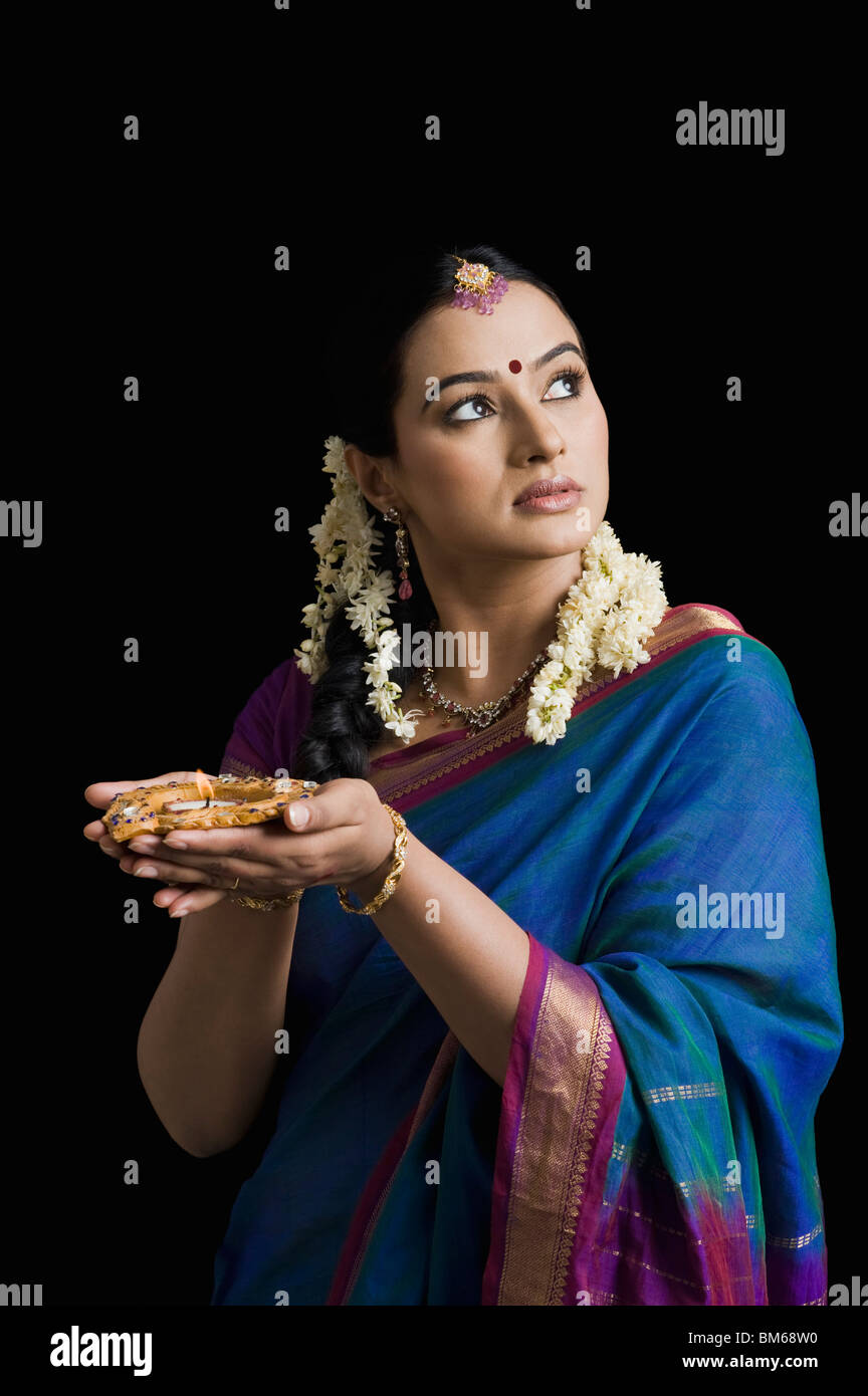 Woman praying with an oil lamp Stock Photo Alamy