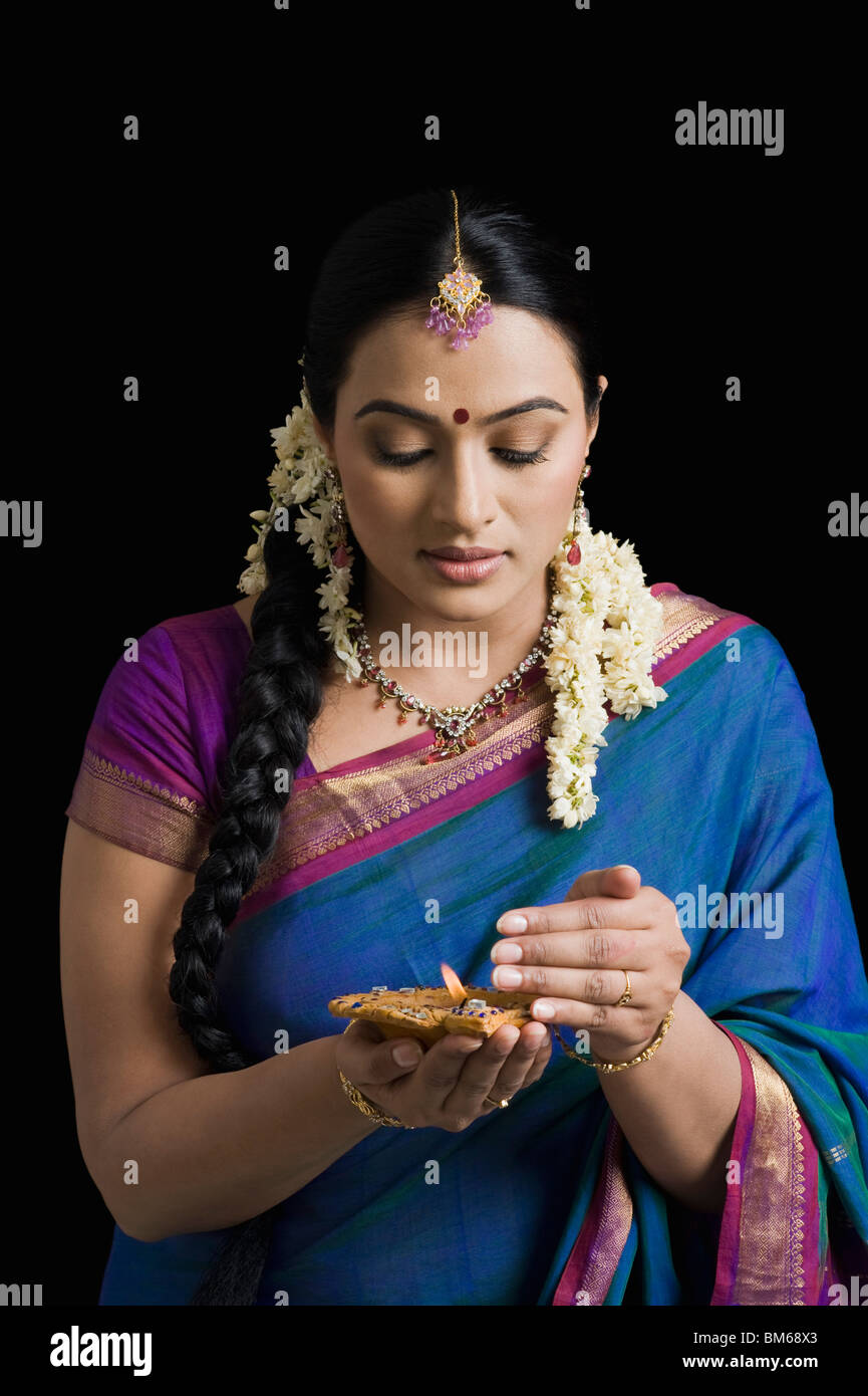 Woman praying with an oil lamp Stock Photo Alamy