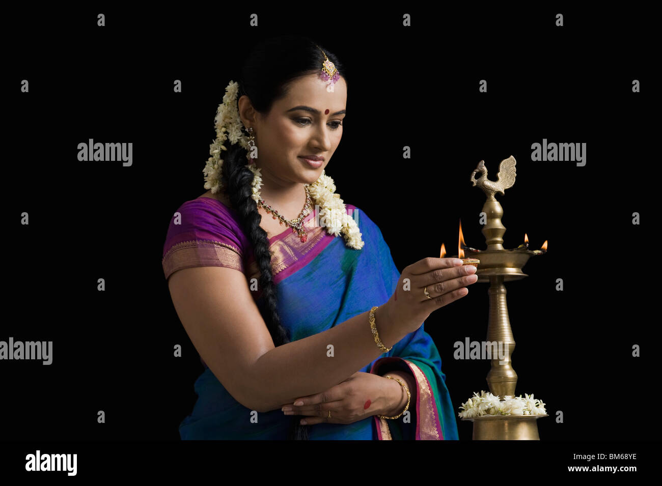 South Indian woman lighting an oil lamp Stock Photo Alamy