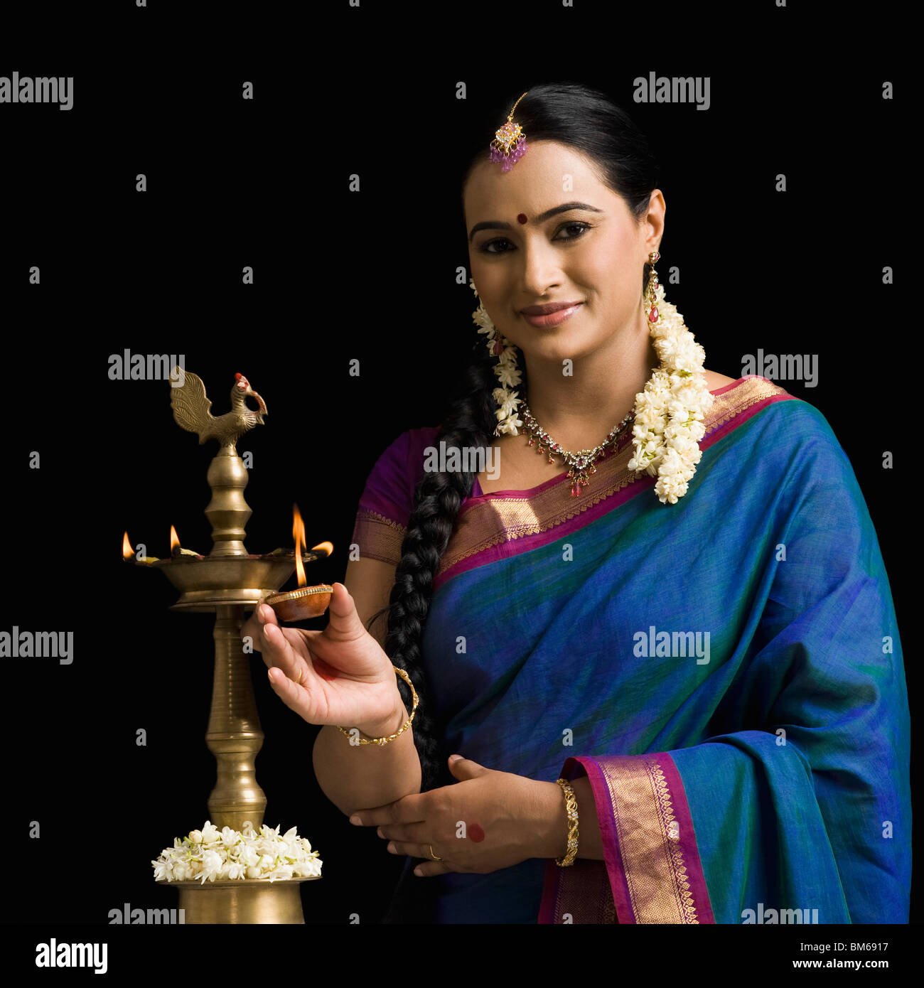 South Indian woman lighting an oil lamp Stock Photo Alamy