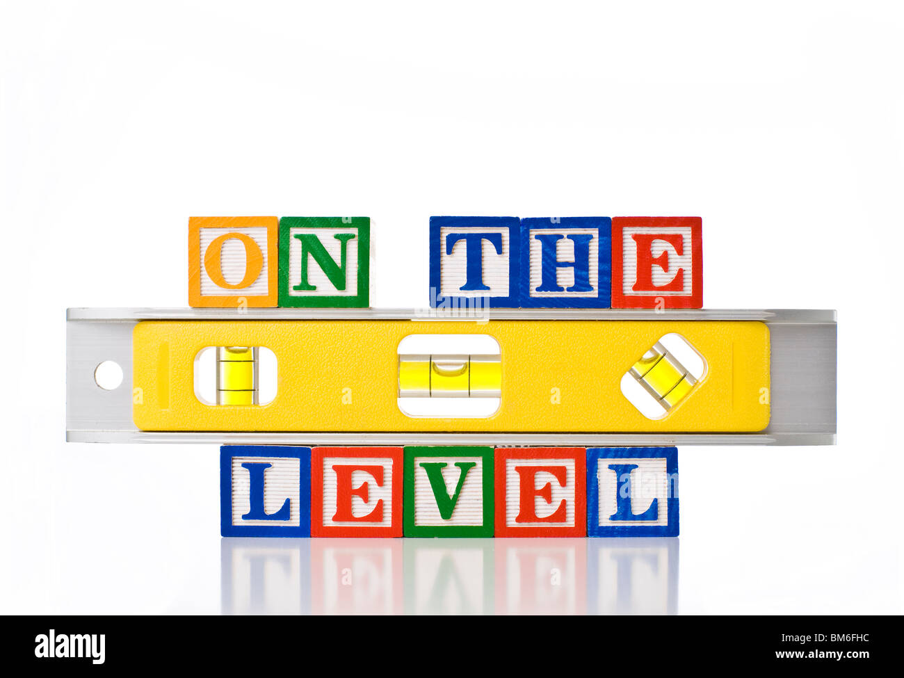 Colorful children's blocks spelling ON THE LEVEL with a yellow spirit level Stock Photo
