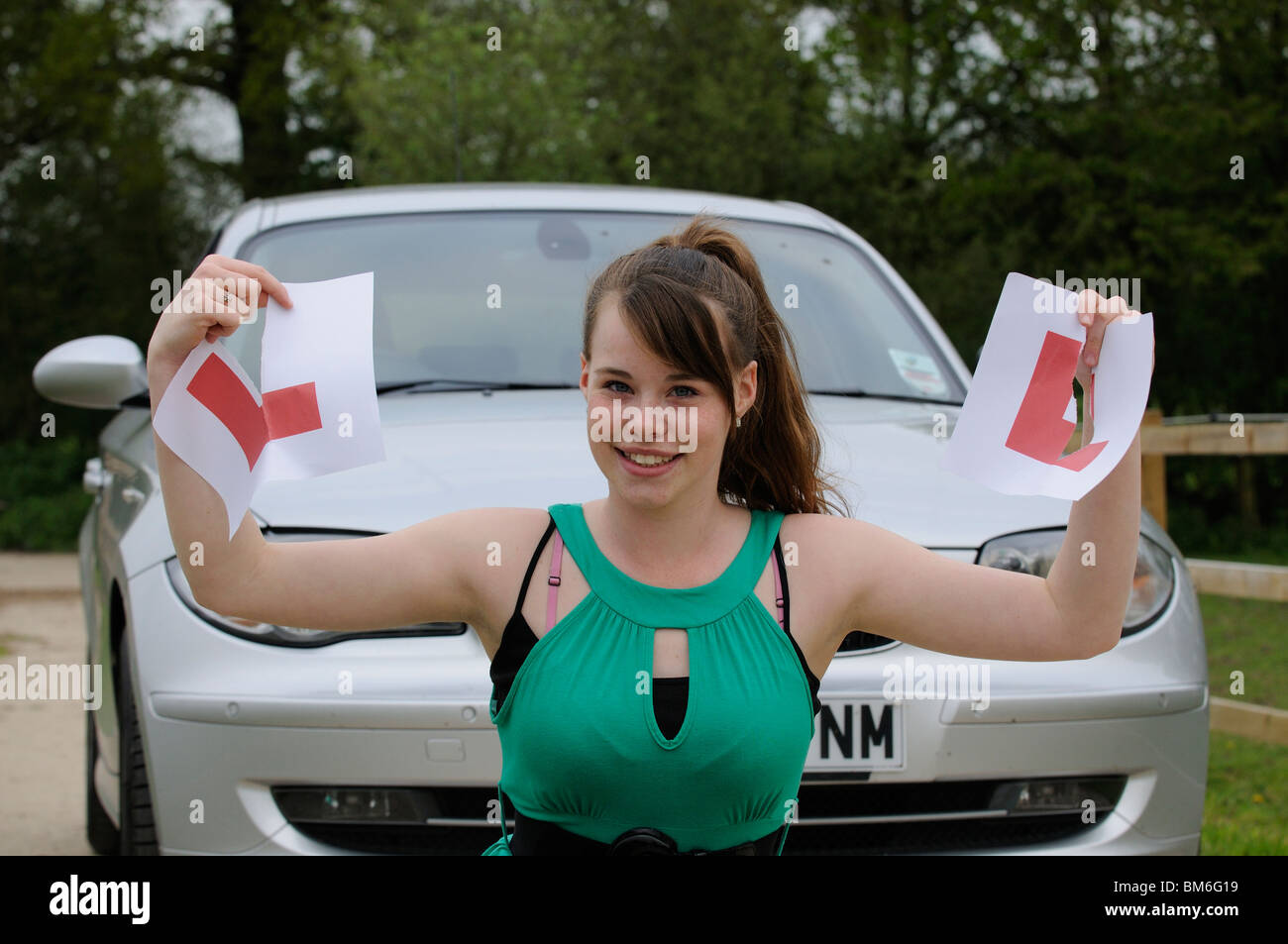 Learner driver tearing up her L plates on passing the driving test Stock Photo