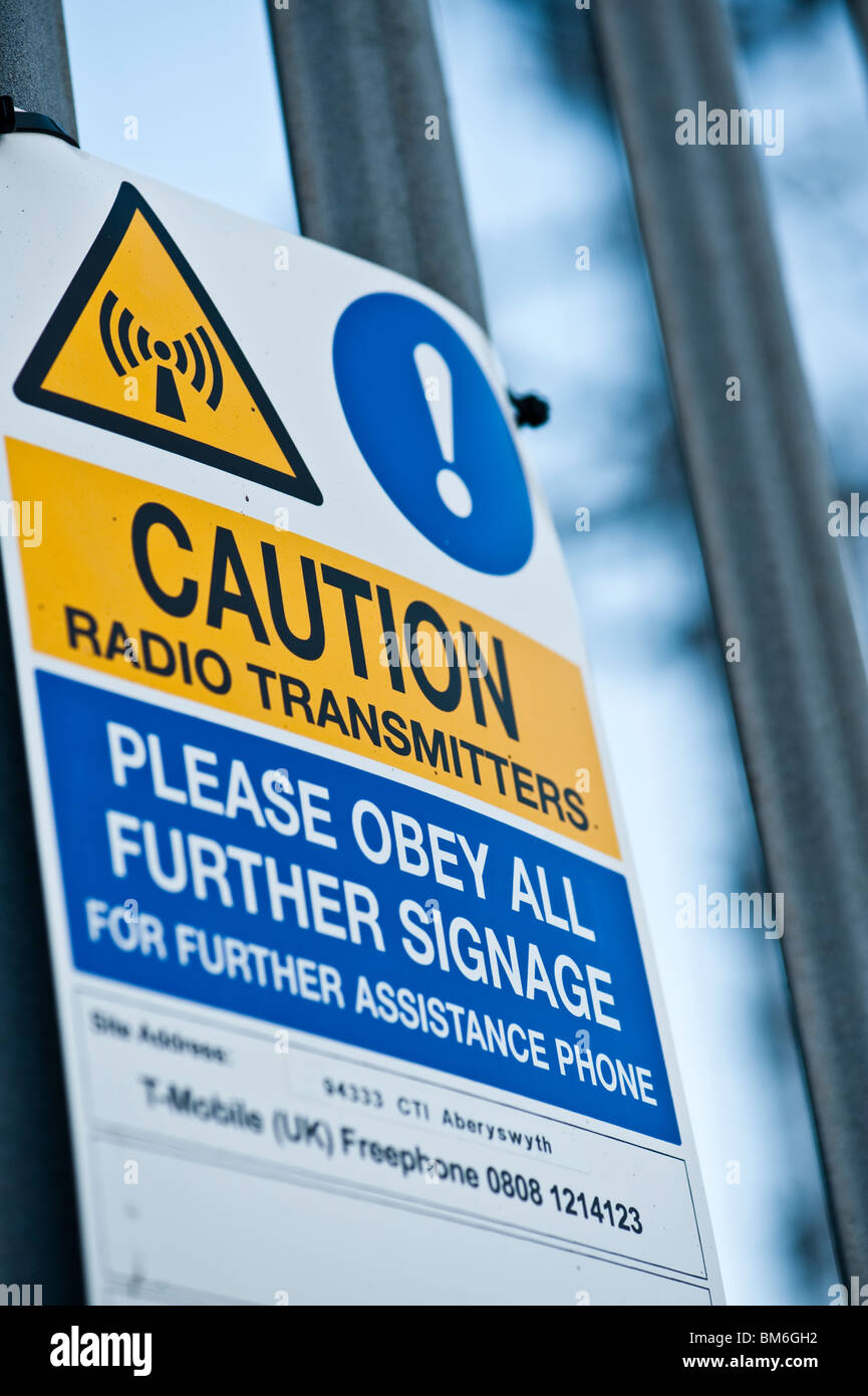 Caution warning radio transmitter radiation danger signs on mobile phone mast, UK Stock Photo