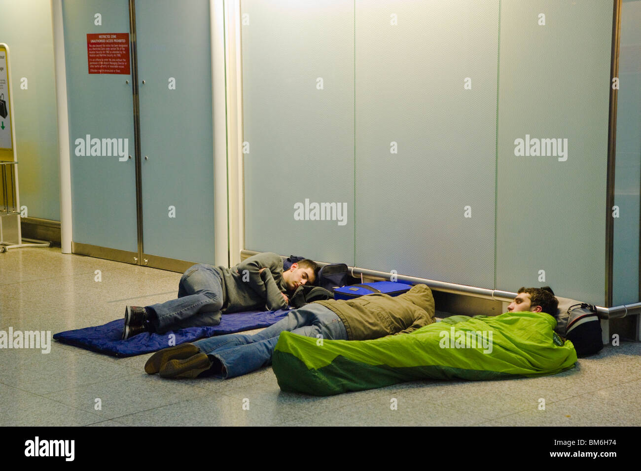 Travellers sleeping at Stansted Airport Stock Photo