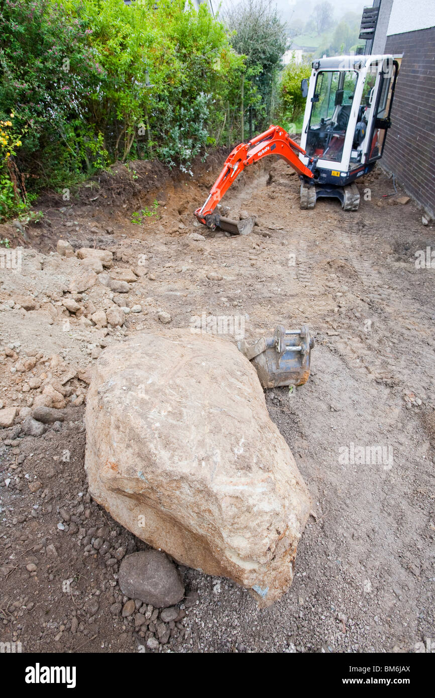 A large boulder pulled out of the boulder clay whilst digging footings for a house extension in Ambleside, UK. Stock Photo